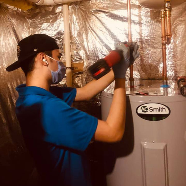 man attaching pipes to water heater
