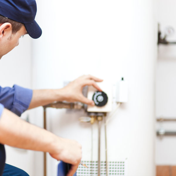 man turning dial on water heater